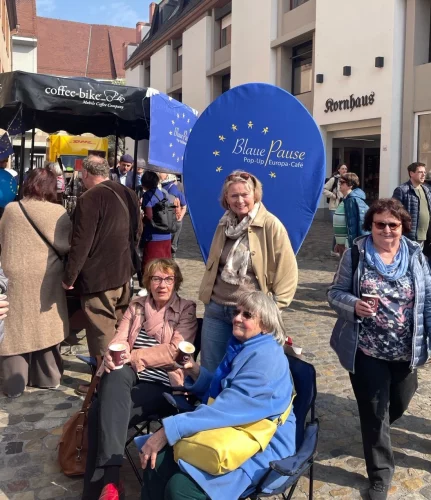 Menschen im Gespräch bei einem Kaffee.