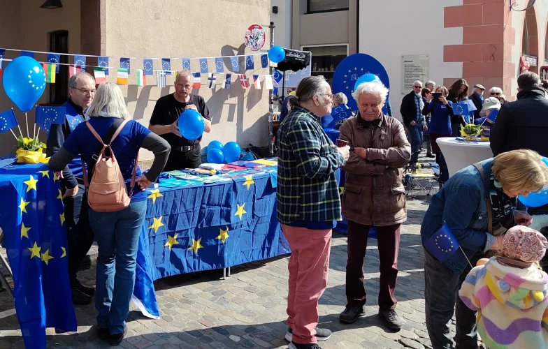 Die letzten Vorbereitungen laufen und Kinder erfreuen sich an den Luftballons und Fähnchen.